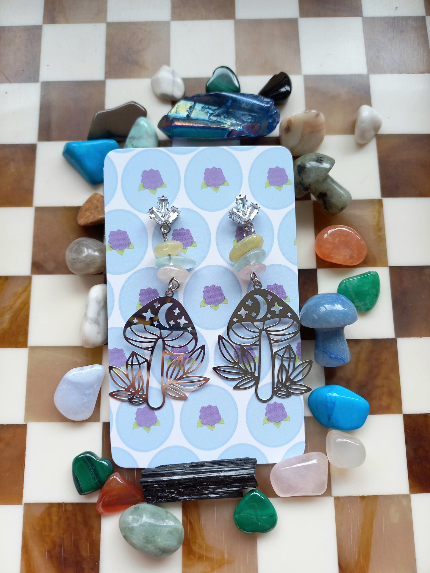 Earring set on a card with colorful stones on a checkered background