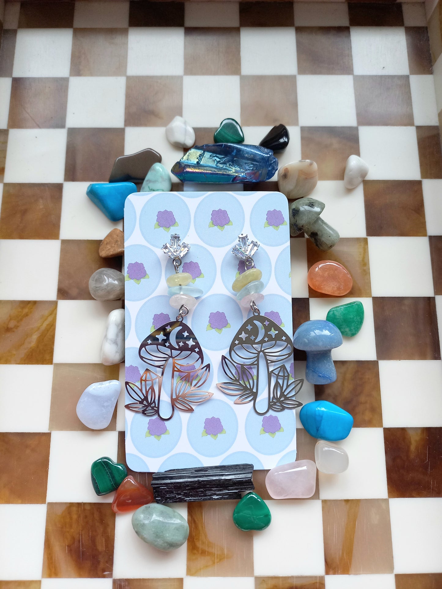 Pack of earrings with decorative stones on a checkered surface